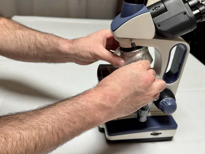 Retrait des protections d'un microscope par une personne.